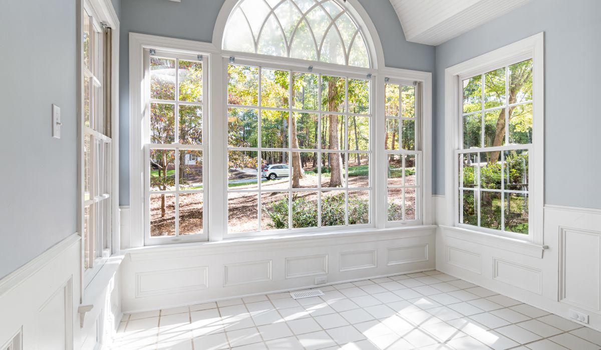 Bright sunroom with a wall of divided-light windows and an arched transom
